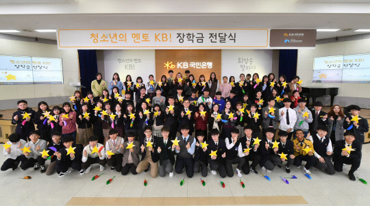 KB국민은행은 20일 서울 여의도 본점에서 지역아동센터 청소년에게 장학금 8억원을 전달했다. 지역아동센터 청소년과 KB국민은행 및 보건복지부 관계자들이 기념촬영을 하고 있다.  KB국민은행 제공